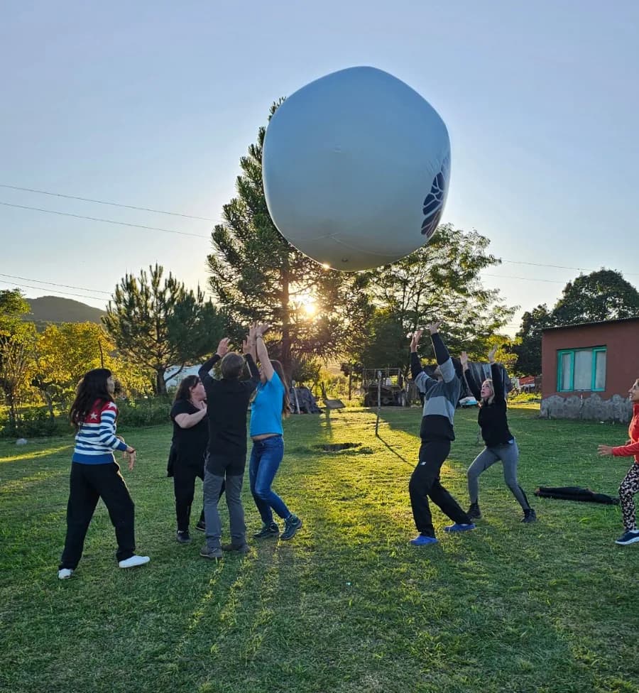 Personas jugando con una pelota grande en un espacio al aire libre.