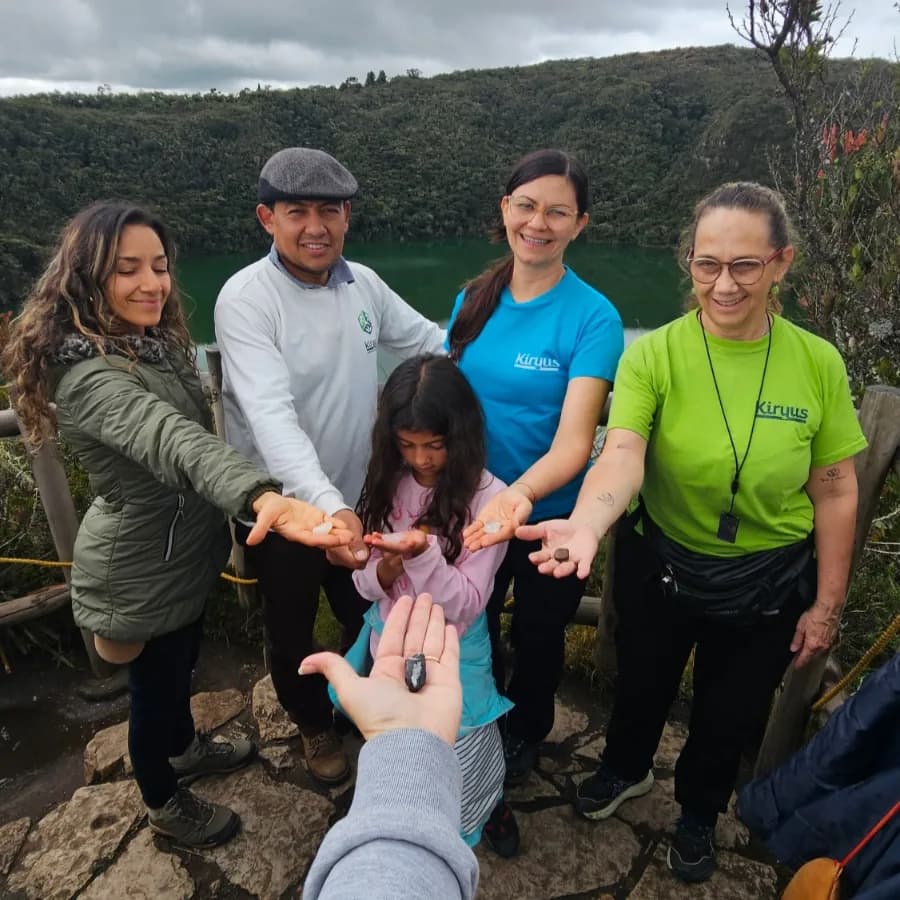 Grupo de personas al aire libre, con montañas al fondo.
