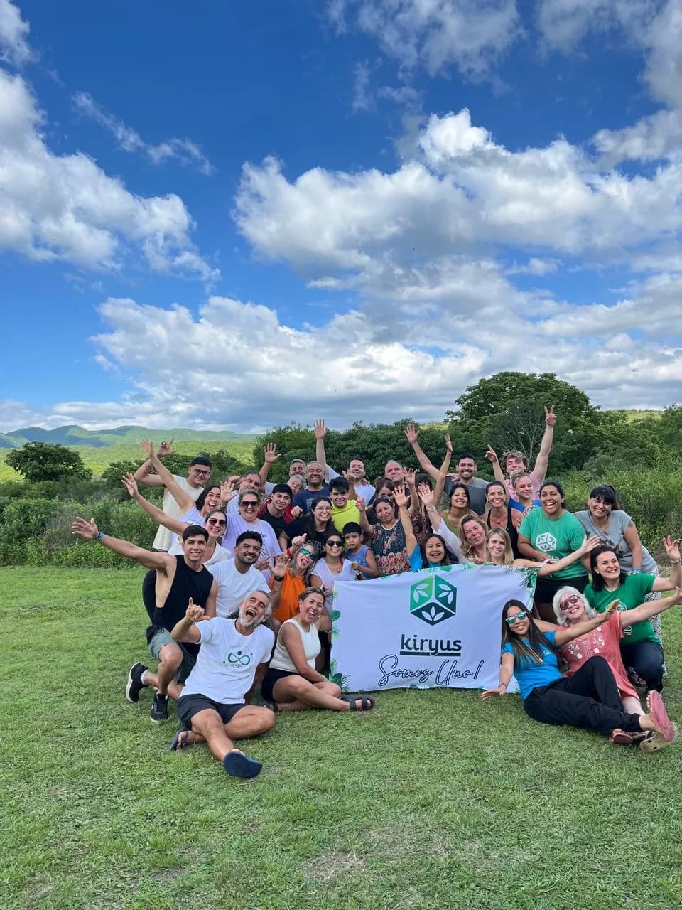 Grupo de personas en un prado con una bandera de Kiryus.