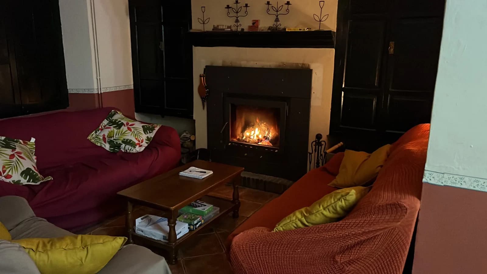 Espacio interior con asientos y una chimenea encendida.